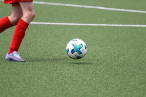 Woman plays soccer on artificial turf field