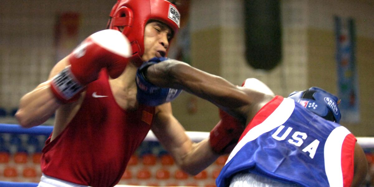 Image of two boxers competing in the ring with headgear