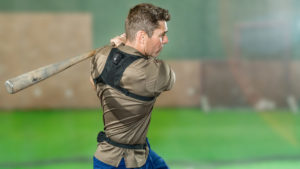A photo of a man wearing the K-Motion vest, showing that a sensor sits on the top of the spine and at the tailbone.