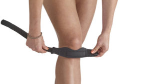 A strap being put around the patellar tendon that can ease pain.