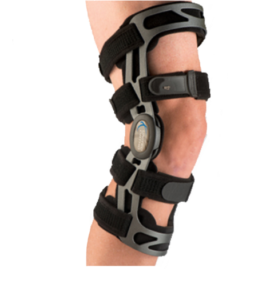 A PCL brace is shown in place on a knee. There are two stabilizing straps above the knee, and two below the knee. They are connected by a metal frame that meets at a hinge joint over the side of the knee.