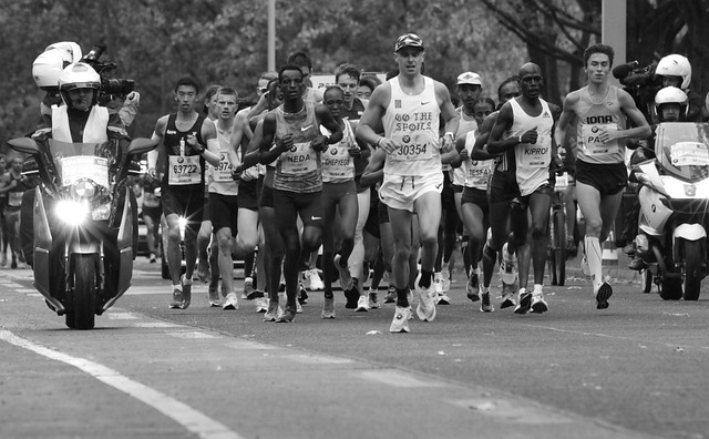 Black and white image of marathon runners racing along a road