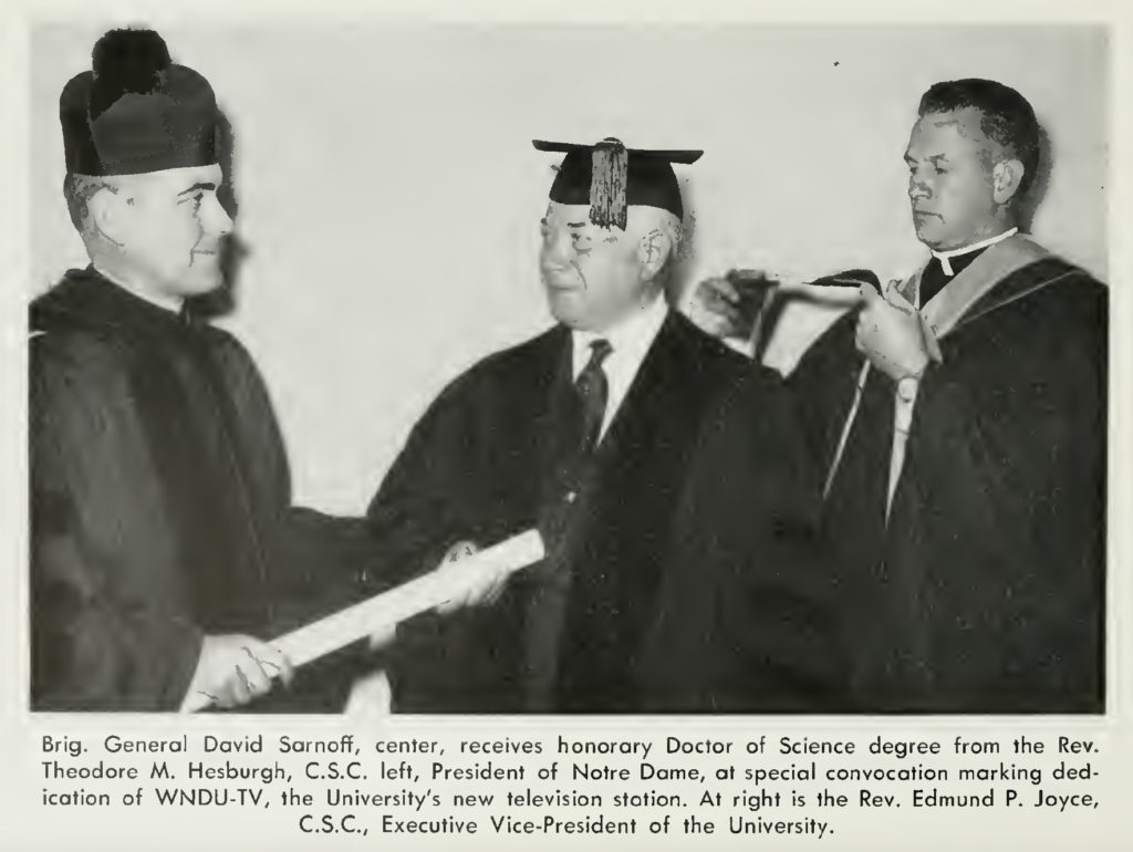 Photo of David Sarnoff receiving an honorary degree from Notre Dame president Rev. Ted Hesburgh while being hooded by Executive VP Rev. Edmund Joyce.
