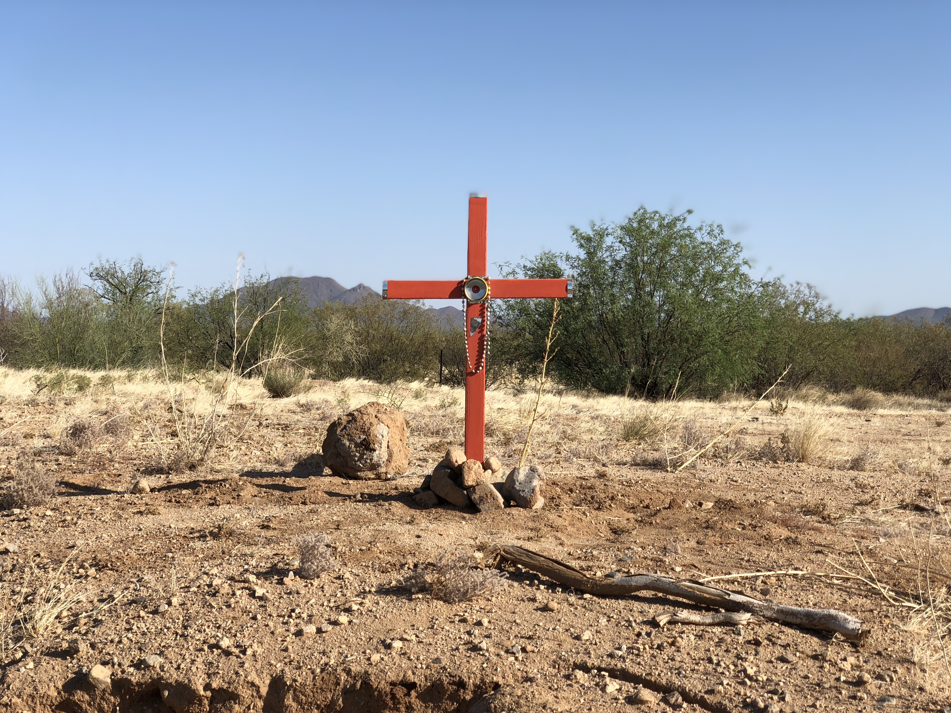 "A cross in the desert, marking the spot where a deceased migrant's body had been found."