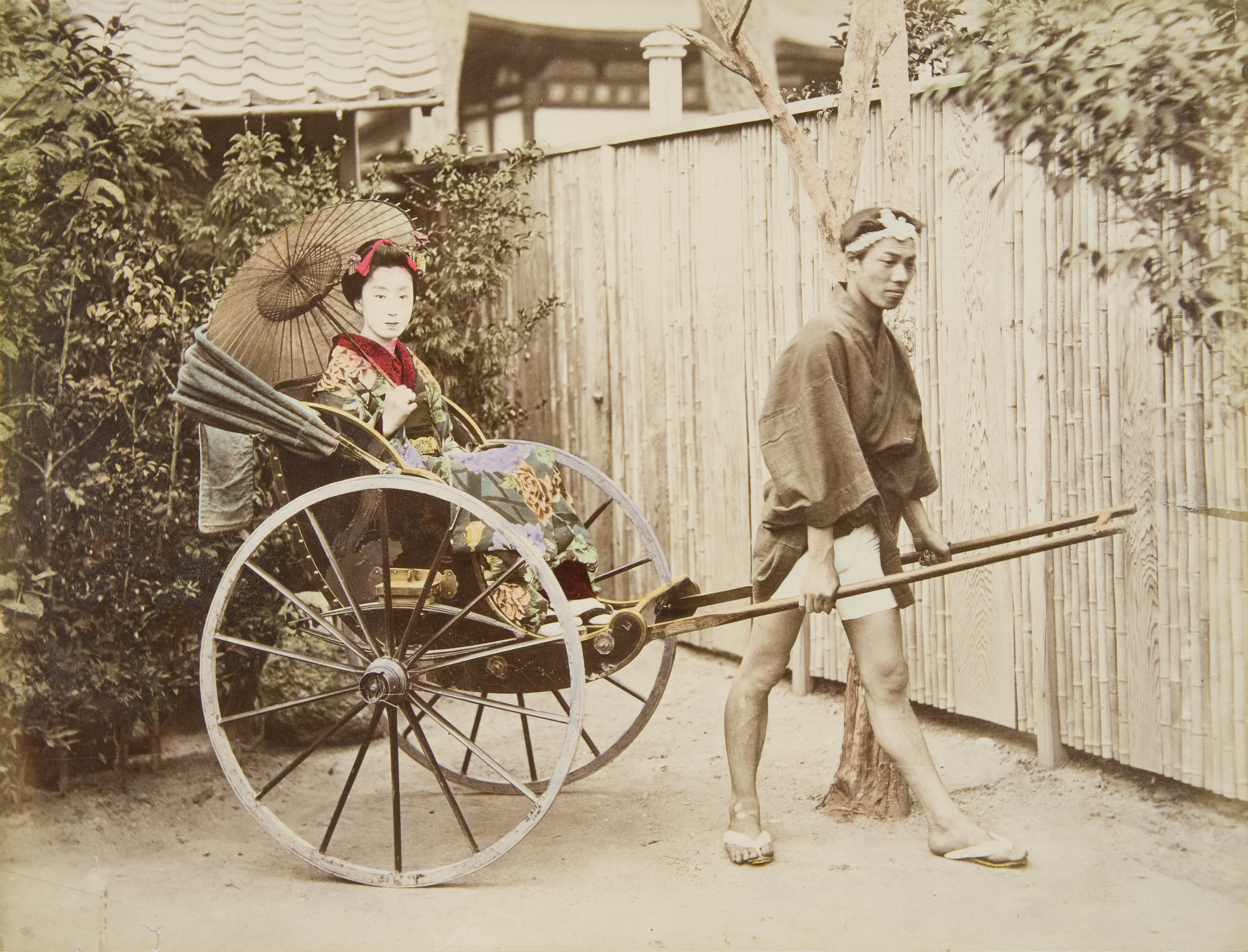 Photograph of man pulling woman in a rickshaw 