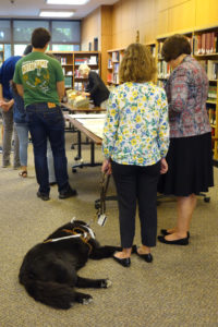 Photo of service dog and student in class in special collections