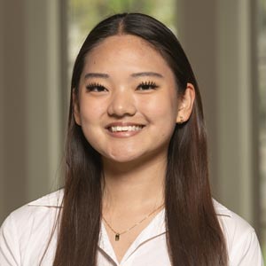 Headshot of Sharon Cho, SWE Fundraising Co-Director, wearing a white blouse, smiling in front of a softly blurred indoor background.