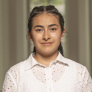 Headshot of Victoria Garcia Jimenez, SWE CEEES Director, wearing a white blouse, smiling in front of a softly blurred indoor background.