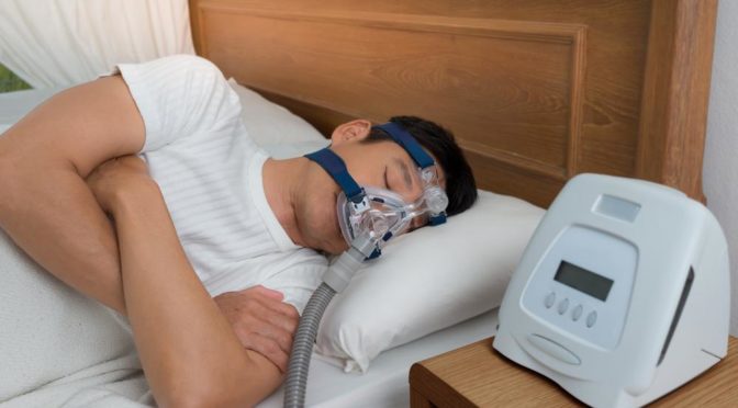 Man sleeping while using CPAP machine