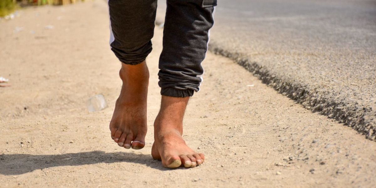 barefoot person walking outdoors during the day
