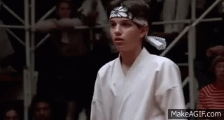 GIF of boy in karate uniform bowing before taking stance to start fighting 