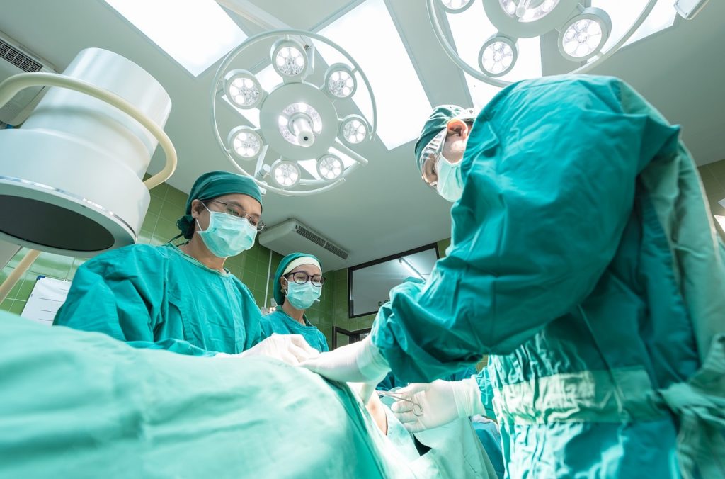 Three doctors performing surgery in an operating room