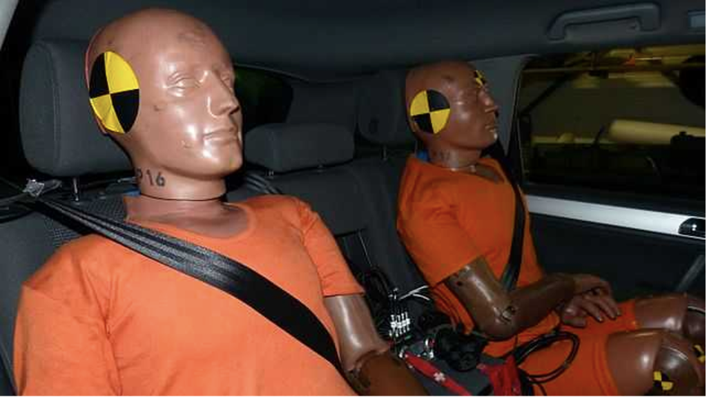 Two fully assembled crash test dummies seated in car awaiting testing