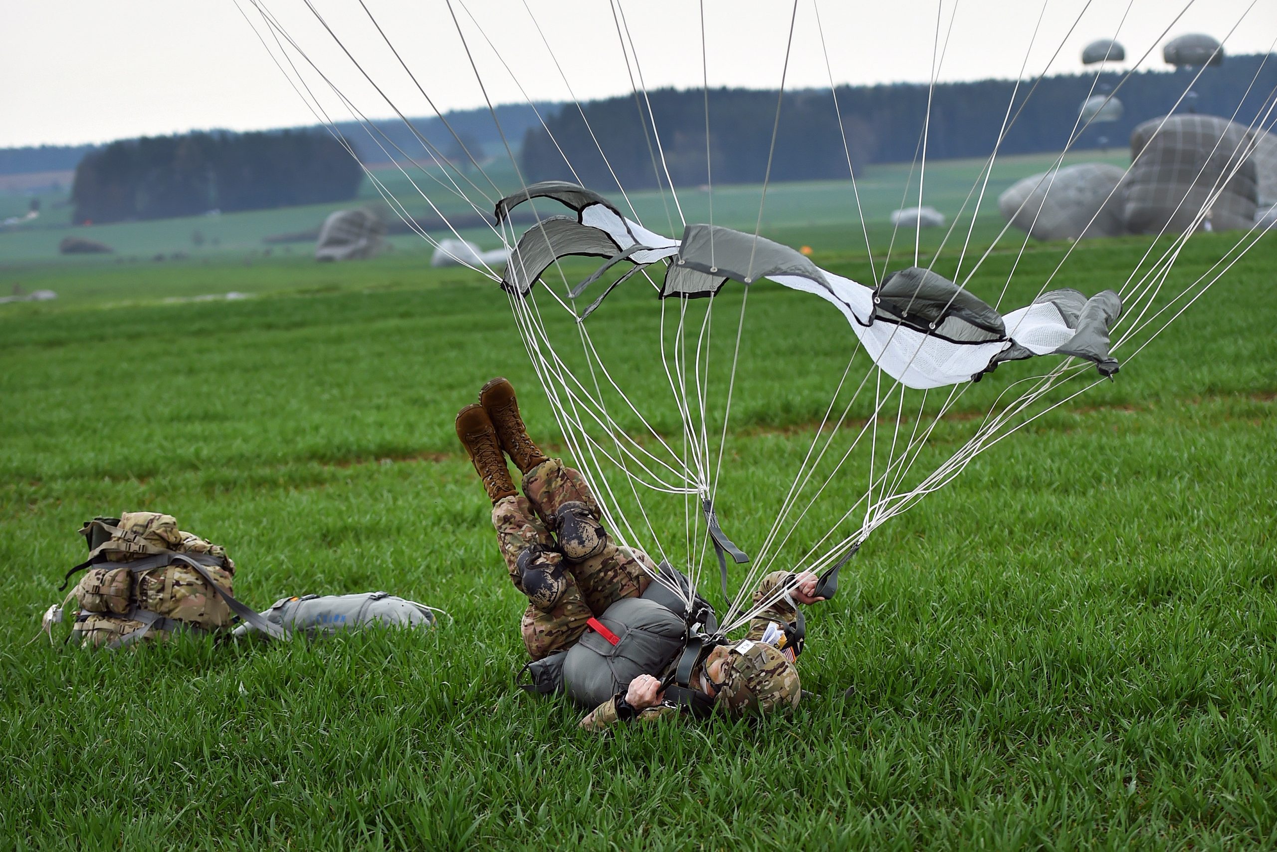 Soldier executing the PLF - rolling onto their back with equipment