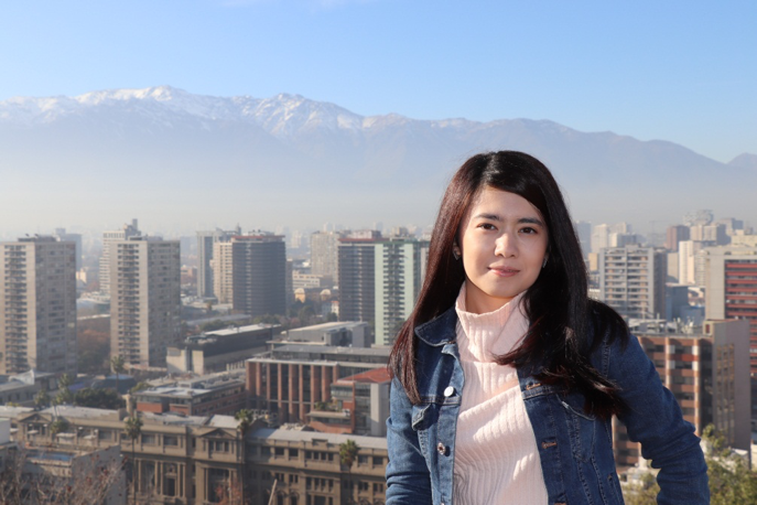 MGA student Mukhlisa Khudayberganova stands on a hill overlooking the city of Santiago. The Andes mountains can be seen in the background.