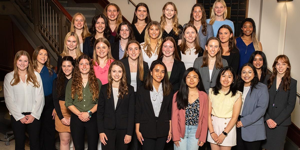 Group photo of the 2024–25 Notre Dame Society of Women Engineers members posed on an indoor staircase in professional attire.