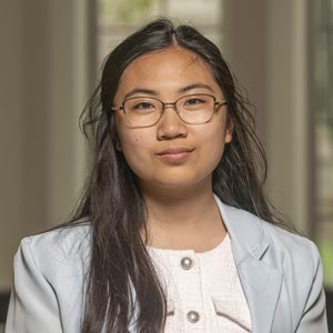 Portrait of Candice Estrada, Vice President of Operations of Notre Dame SWE, smiling and wearing glasses and a light blue blazer.