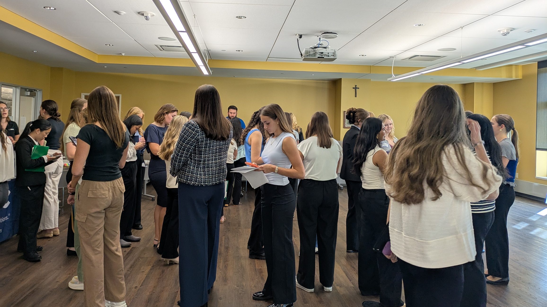 Room of SWE members waiting in lines to speak with recruiters at a networking event.